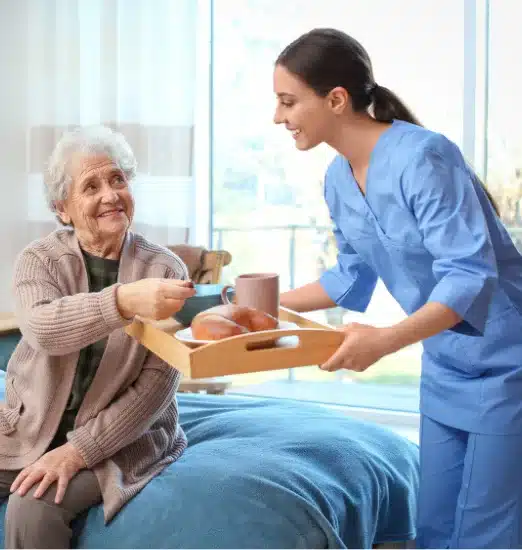 Caregiver offering a meal to a senior client at home